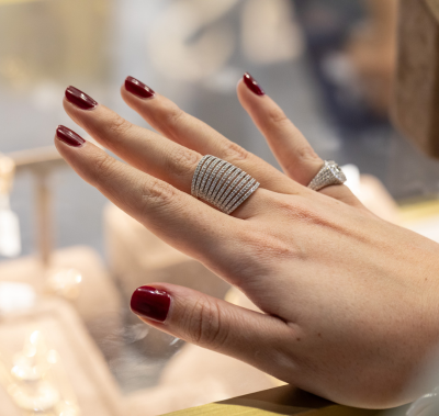 A woman elegantly displays a ring on her hand, showcasing its beauty and significance.