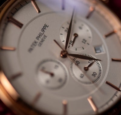 A close-up view of a watch featuring a brown leather strap, highlighting its elegant design and craftsmanship.