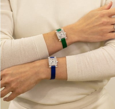  A stylish watch featuring a green strap and a classic white face, perfect for any occasion.
