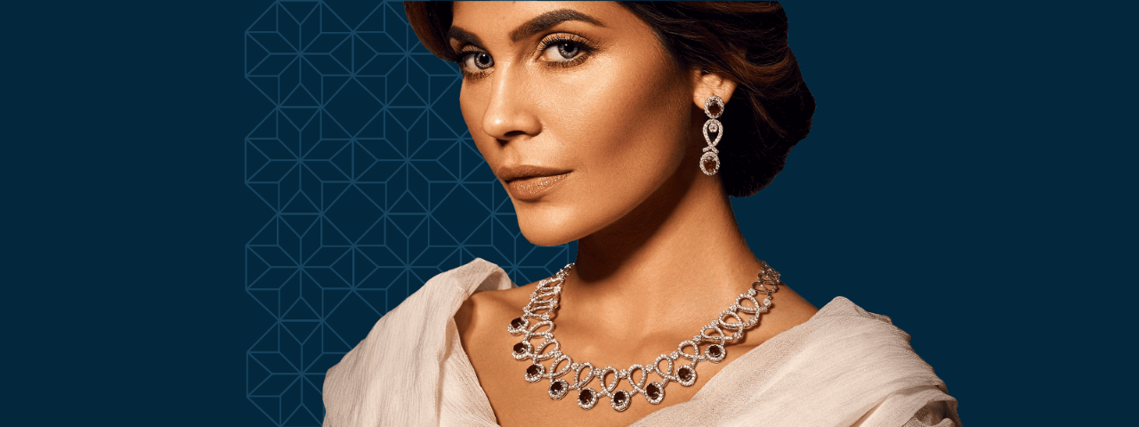 A model with her hand on her neck, showcasing a ring and matching earring.