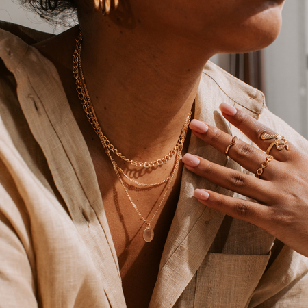 layered necklaces and gold rings